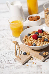 breakfast with homemade granola with nuts and berries, vertical top view
