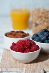 fresh berries, nuts, muesli and orange juice, vertical