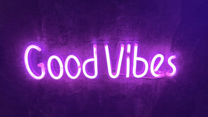 A purple neon sign on a dark surface reads "Good Vibes".
Concept of positive messaging.