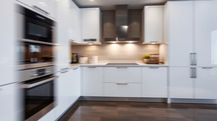 A sleek, modern kitchen interior features contemporary cabinets, stainless steel appliances, and a spacious island with a breakfast bar, all resting on a warm wood floor