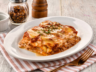 LASANE AL RAGU lasagne with meat sauce served in dish isolated on wooden table side view of italian fast food