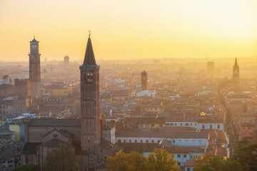 Fototapeta premium Aerial sunset view of Verona old town with Basilica di Santa Anastasia, Lamberti tower, medieval architecture, Veneto, Italy. Italian cityscape. Travel destination in Europe