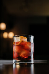 Negroni cocktail with orange zest on wooden table