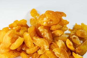 A close-up view of vibrant golden-yellow freeze-dried quince pieces against a white background. The texture and detail of the dried fruit are highlighted.