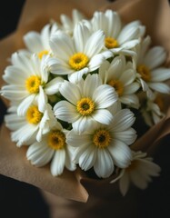 Obraz premium A beautiful bouquet of white daisy flowers with bright yellow centers and brown wrapping