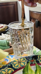 Stirs mineral water in a glass
