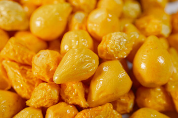 A detailed close-up of freeze-dried Argentine chili peppers, showcasing their vibrant yellow color, glossy texture, and seeds. Perfect for culinary or spice applications.