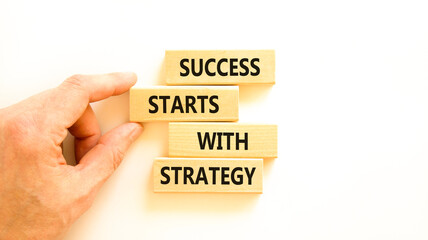Success starts with strategy symbol. Concept words Success starts with strategy on beautiful wooden blocks. Beautiful white background. Business and success starts with strategy concept. Copy space.