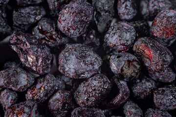 A detailed close-up of freeze-dried honeysuckle berries, showcasing their deep purple hue, wrinkled texture, and natural appeal. Perfect for culinary or snack applications.