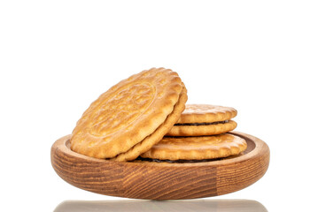 Several sweet delicious cookies on a wooden saucer, close-up, isolated on a white background.