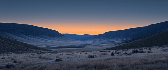 Serene sunrise over a vast valley between mountains.