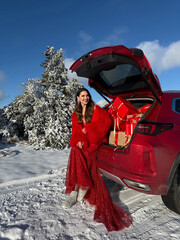 beautiful woman with dark hair in luxurious evening dress with accessories posing in the snowy...
