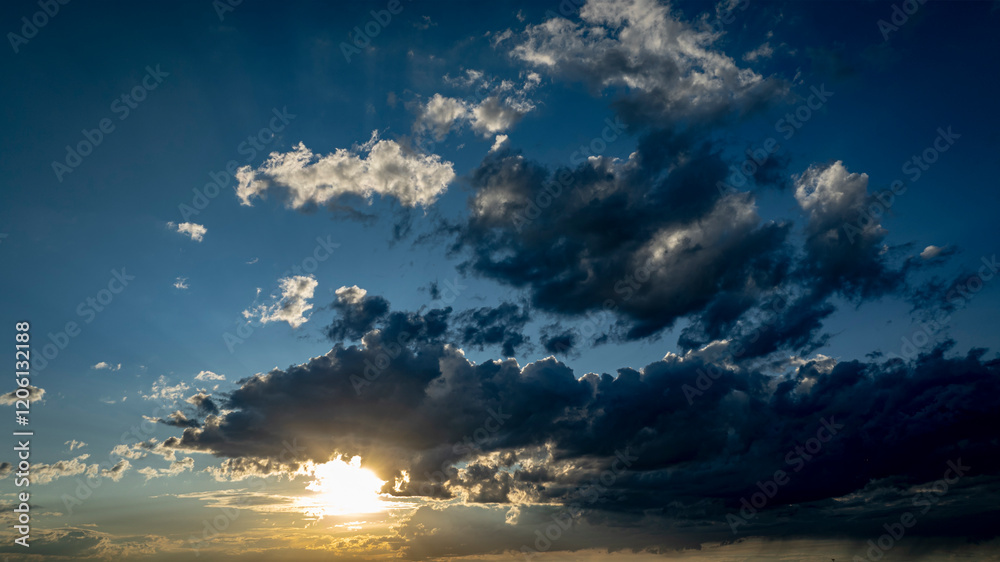Wall mural a stunning display of colors fills the sky as the sun sets, casting shadows on the clouds and creati
