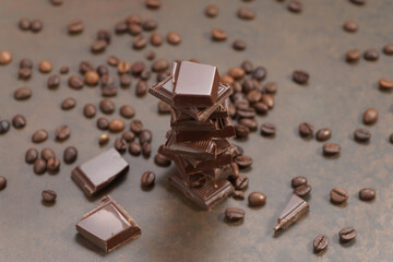 Broken dark chocolate and coffee beans on a wooden table