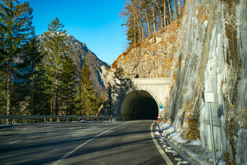 Protective metal fences protect against rock falls along a mountain road. Entering a tunnel on a...