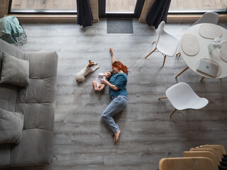 Top view of caucasian woman lying on floor with newborn son and jack russell terrier dog. 