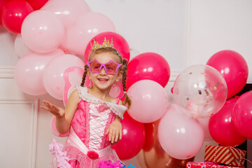 Cute girl dressed as princess with pink glasses, crown at party © Sergey Novikov