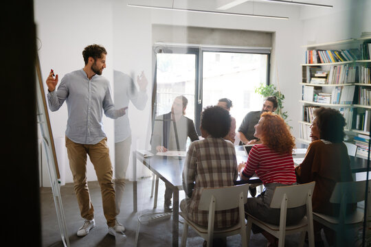 Diverse employees gathered in the office having fun during brainstorming while discussing new ideas