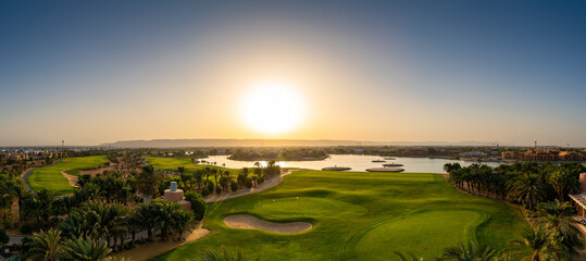 Scenic Sunrise Over a Lakeside Golf Course at El Gouna Red Sea Agypt With Palm Trees and Bright Sky