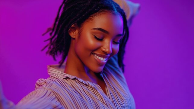 A young woman with dreadlocks is happy and smiling, holding a cell phone