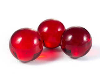 Three red glass balls are sitting on a white background