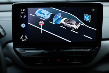 The display of an electric car, where you can select assistants to assist the driver in movement in the menu. Assistant selection menu. Assistants for safe driving on electric vehicles