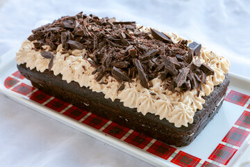 A slice of rich dark homemade chocolate cake sprinkled with chocolate chips