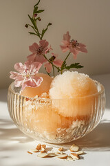 Peach sorbet with almond slivers, garnished with delicate pink flowers. A refreshing summer treat.