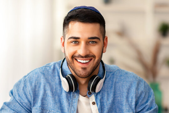 Online Video Call. Portrait of smiling jewish man in kipa having virtual conference with colleagues or students using computer, talkng and gestirung, sitting at desk at home office, webcamera view