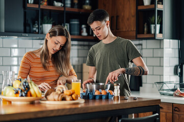 Young lesbian couple preparing breakfast together at home