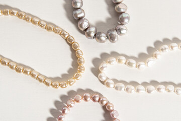 Pearl threads or necklaces on white background. Different types of natural pearls. Sea pearls