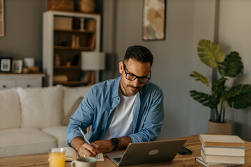 Comfortable workspace. Man balancing work and home finances in a bright living room
