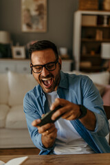 Mobile gamer. Man with earphones enjoying a video game on his smartphone in a well-lit space © La Famiglia