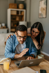 Casual teamwork. Man and woman discussing ideas over a laptop in a well-lit living room