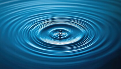 A water droplet falling into the ocean, creating ripples on its blue surface.
