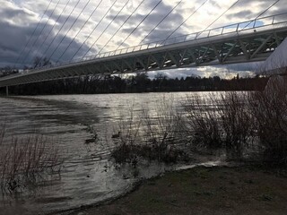 Dramatic Sundial Bridge Silhouette: Dark and moody shot of the bridge over reflective water under a stormy sky
