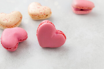 French macarons in the shape of hearts, neatly placed on a light background, symbolizing elegance and romance. Valentine's day, mother's day, congratulations. With love.
