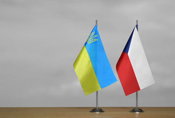 Tabletop flags of Ukraine and Czech Republic on a gray blurred background