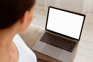 Naklejka premium Unrecognizable Woman Looking At Laptop Empty Screen Browsing Internet Sitting At Home. Mockup, Selective Focus