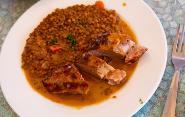 Delicious pork tenderloin with mousserons sauce and lentils on plate