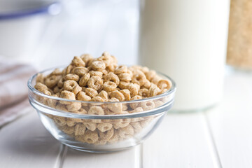 Sweet honey cereal rings in bowl on white table.