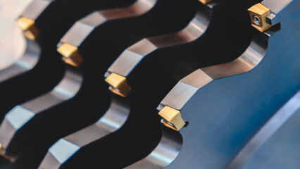 A row of metal milling cutters with a blue tint. The tools are arranged in a line and appear to be the same size. © Aleksandr Matveev
