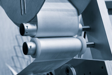 Fragment of the conveyor of sticking labeling machine. Abstract industrial background.