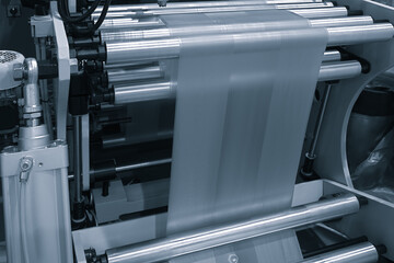 Automatic polyethylene plastic bag production machine with lighting effect. Close-up of the roller...