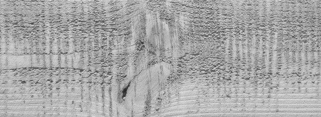 Obraz premium A wooden surface with a grainy texture. The wood appears to be aged and worn, giving it a rustic and natural feel. The grain of the wood is visible