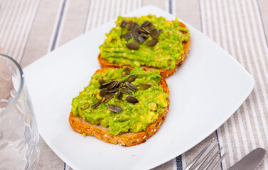 Sandwich with guacamole butter and seeds on whole grain bread, healthy eating concept, top view