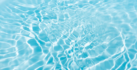 Blue water with ripples on the surface. Defocus blurred transparent blue colored clear calm water surface texture with splashes and bubbles. Water waves with shining pattern texture background.