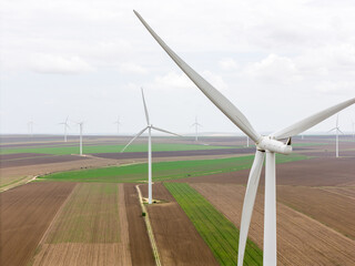 Aerial drone view of turbines windfarm on a green hillside
