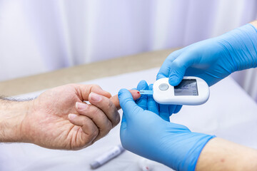 Close-up of medical worker taking patient's blood sample with finger prick kit. Medical concept....