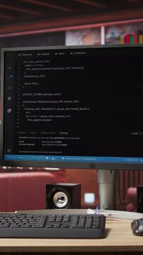 Vertical video UI on computer monitor in home office with programming script being executed. Empty modern apartment room with coding application used by remote employee to write code, jib up shot